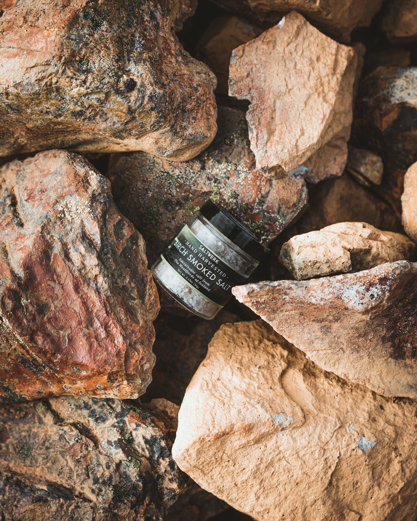 Jar of Saltverk Birch Smoked Salt resting on rocks