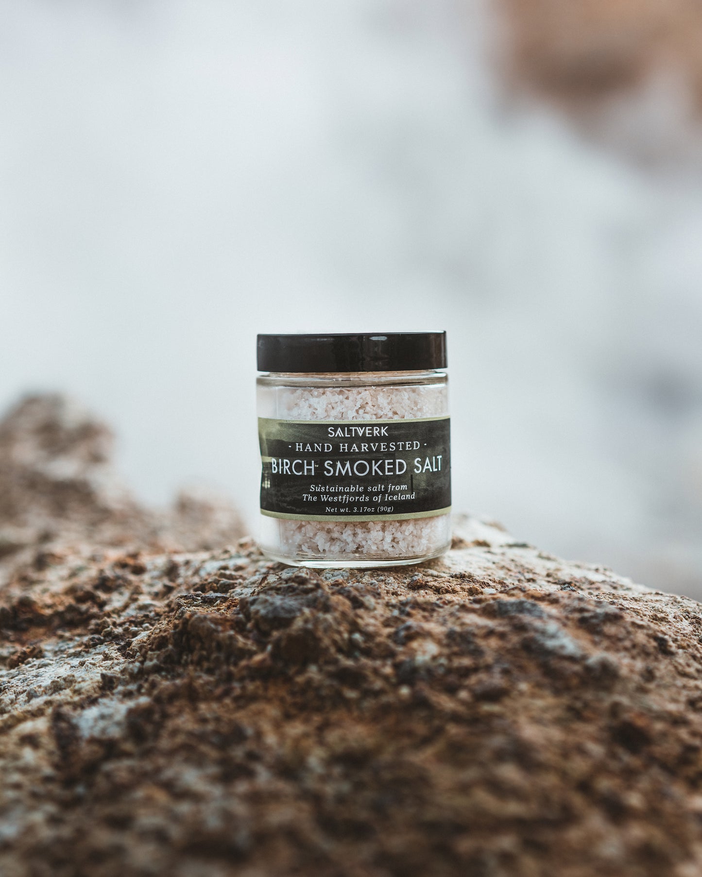 Jar of Saltverk Birch Smoked Salt on brown Icelandic rocks
