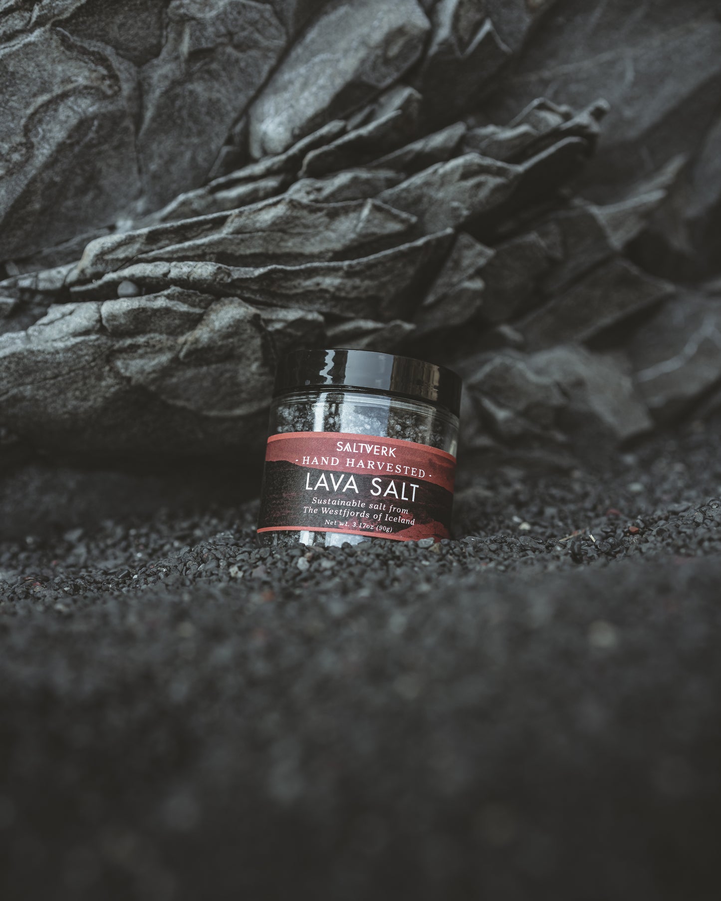 Jar of lava salt on a dark textured surface